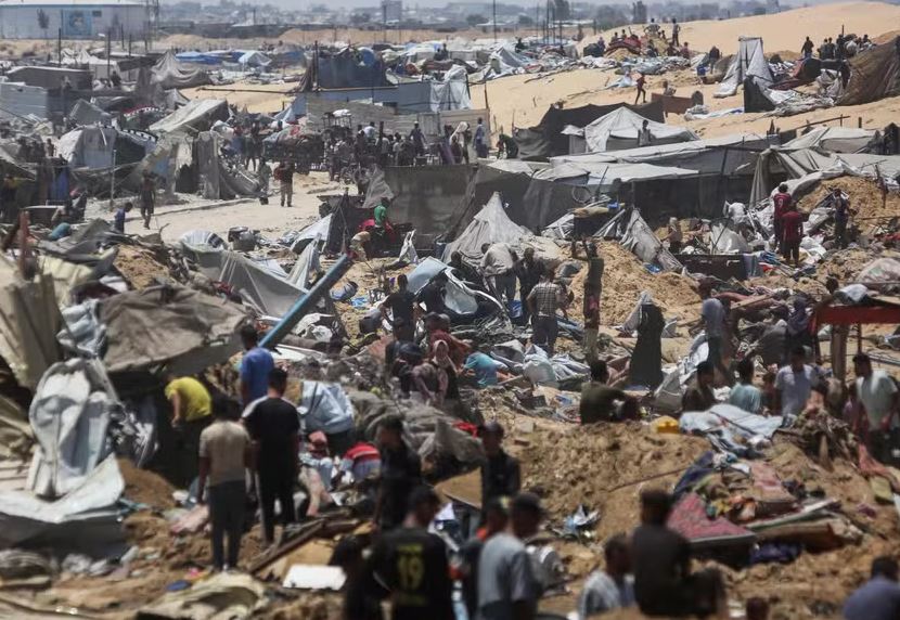 Palestinos inspecionam a destruição em um campo improvisado para deslocados após uma incursão relatada no dia anterior por tanques israelenses na área de Khan Yunis