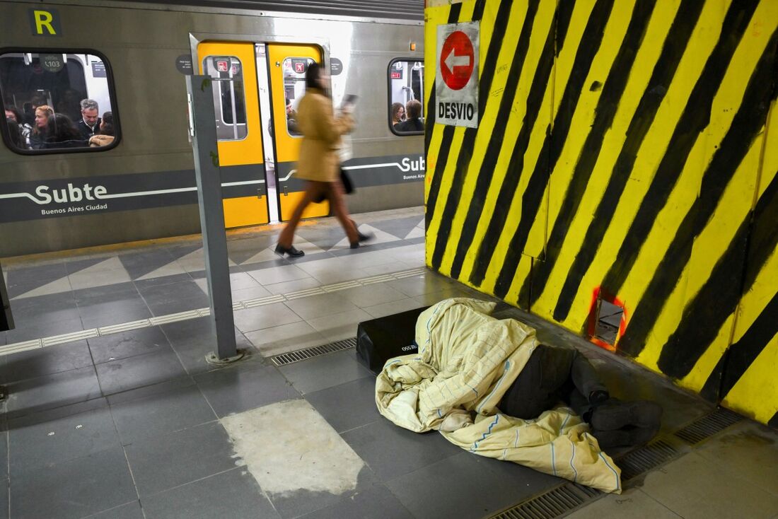 Homem dorme no chão em plataforma de metrô de Buenos Aires