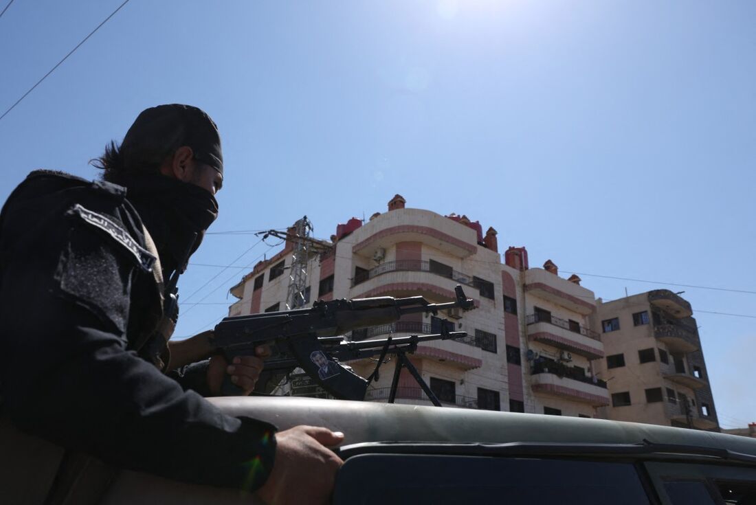 Membro das forças sírias em cima de um veículo militar