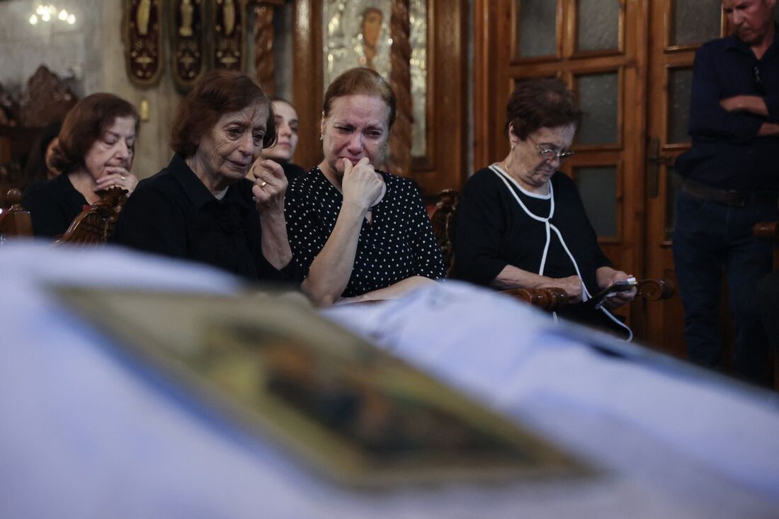 Cristãos palestinos lamentam Saad Salameh e Foumia Ayyad, mortos anteriormente em um ataque israelense que atingiu a Igreja da Sagrada Família na Cidade de Gaza, durante sua cerimônia fúnebre na Igreja de São Porfírio