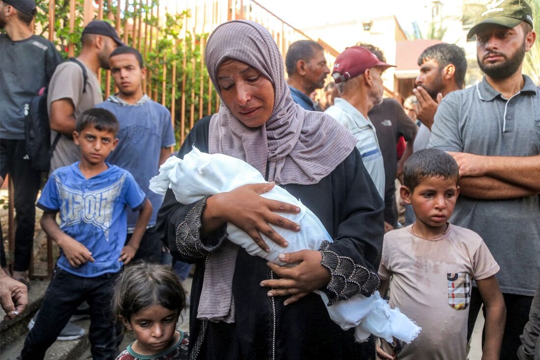 Mãe carrega criança morta por desnutrição e fome na faixa de Gaza