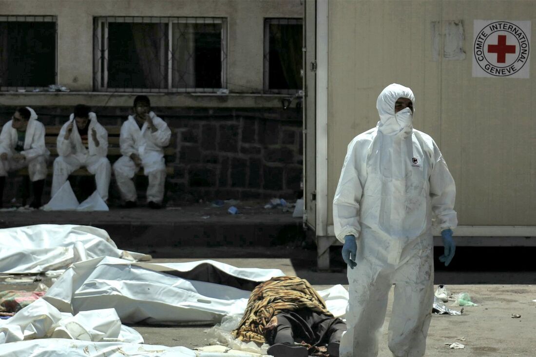 Trabalhador da saúde caminha entre corpos ensacados em Sweida