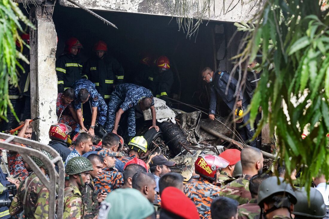O corpo de bombeiros e a equipe de segurança de Bangladesh realizam uma operação de busca e resgate após um jato de treinamento da Força Aérea cair em uma escola em Dhaka