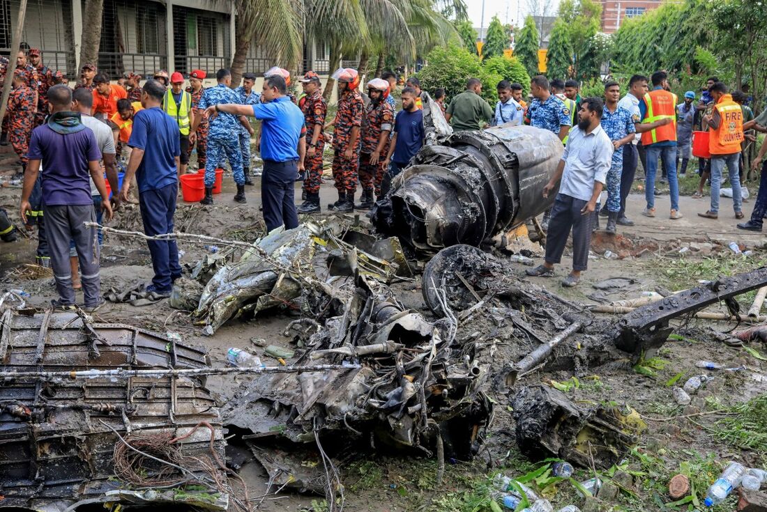 O corpo de bombeiros e a equipe de segurança de Bangladesh realizam uma operação de busca e resgate após um jato de treinamento da Força Aérea cair em uma escola em Dhaka 