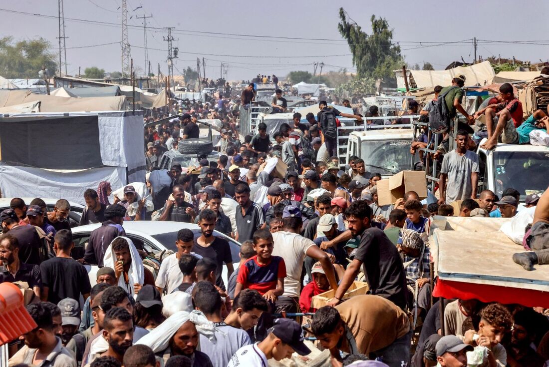 Palestinos carregam pertences pessoais na área de Mawasi, em Rafah, no sul da Faixa de Gaza, em 28 de julho de 2025