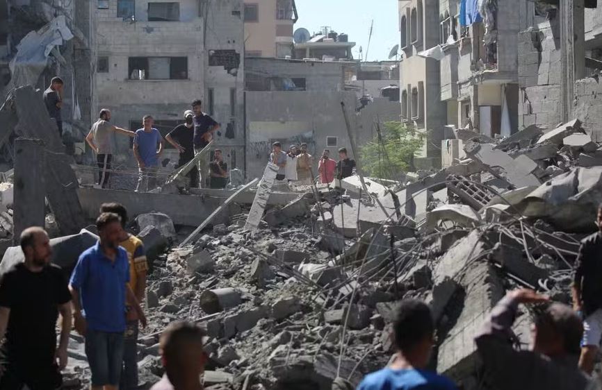 Palestinos inspecionam os danos após um ataque israelense no campo de al-Bureij, no centro da Faixa de Gaza, em 4 de julho de 2025 