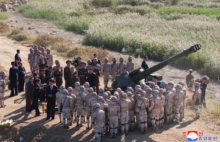Líder da Coreia do Norte, Kim Jong-un (no centro, de preto) acompanha teste de artilharia ao lado de soldados