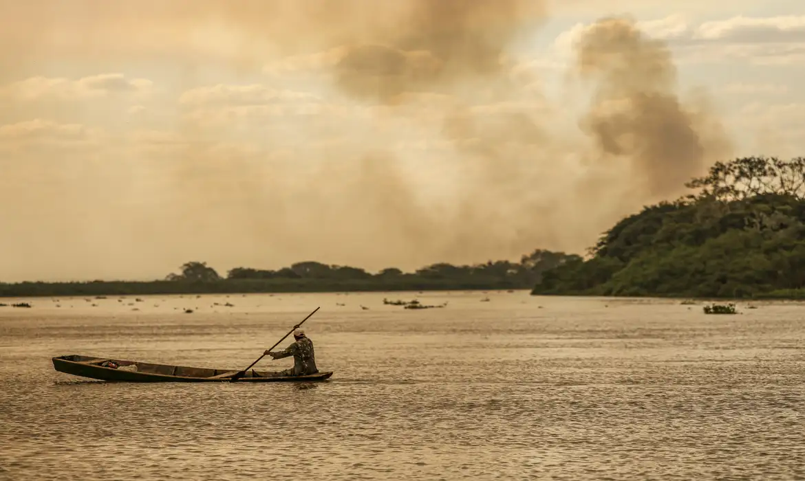 Homem remando em sua canoa num Rio