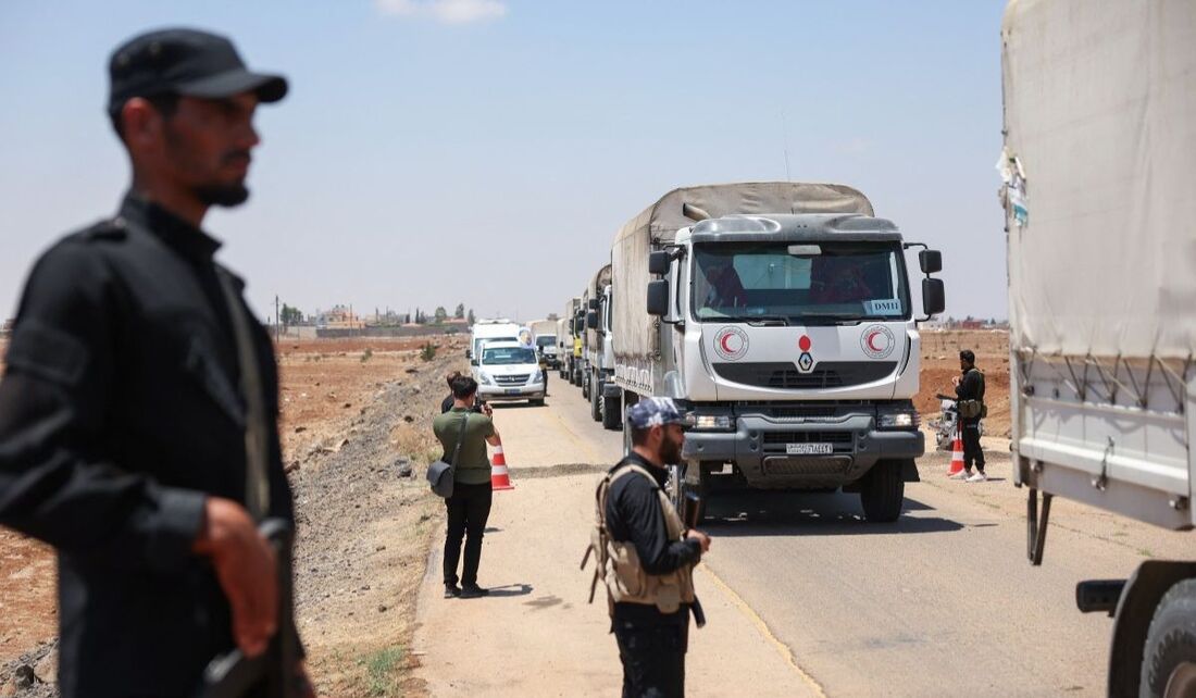 Um comboio do Crescente Vermelho Sírio carregando ajuda humanitária fornecida pelo governo interino da Síria atravessa um posto de controle