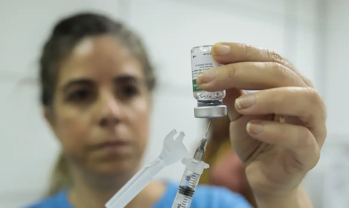 Profissional manipulando vacina