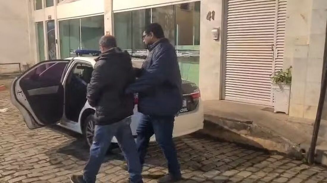 O suspeito preso é encaminhado para a viatura da Polícia Civil
