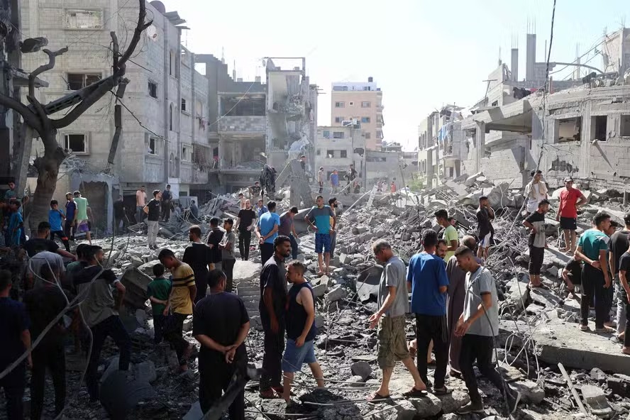 Palestinos inspecionam danos causados por ataque aéreo ao campo de al-Bureij, na Faixa de Gaza 