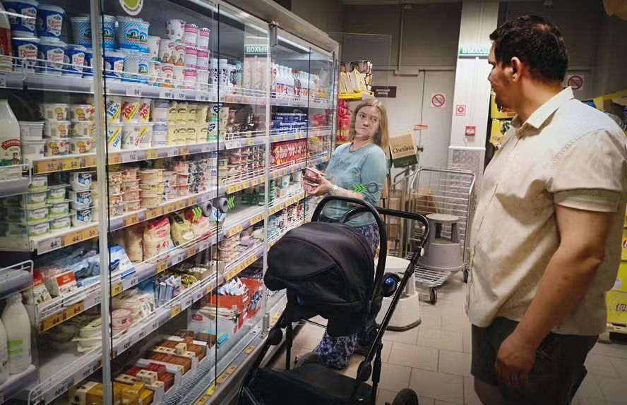 Maria Tyabut e seu marido Sergei Duzhikov escolhem comida em uma loja no subúrbio de Mytishchi, em Moscou 