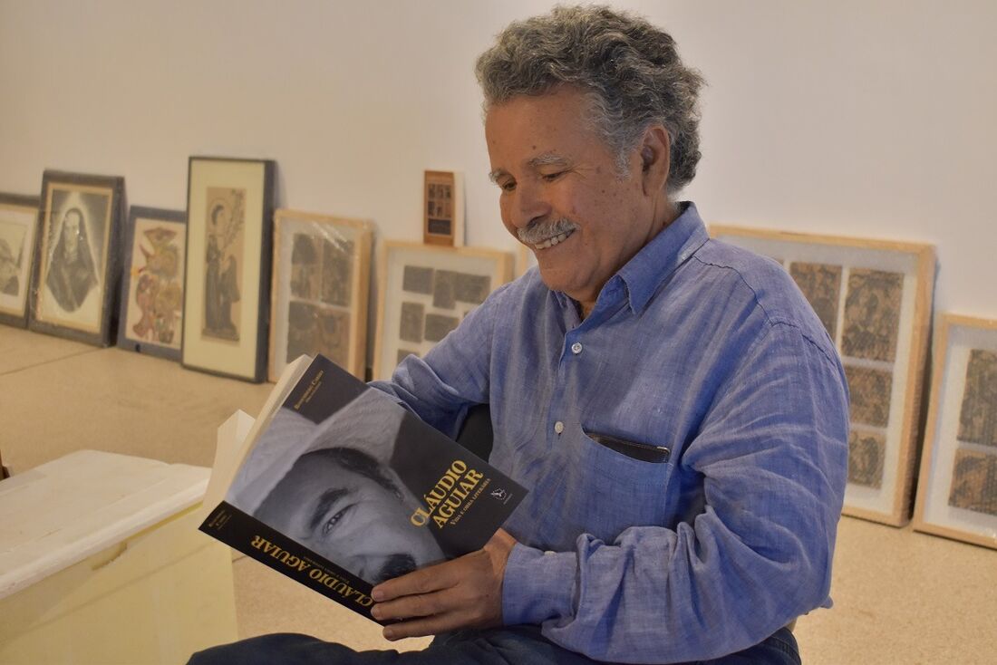 Cláudio Aguiar segurando o livro sobre sua vida