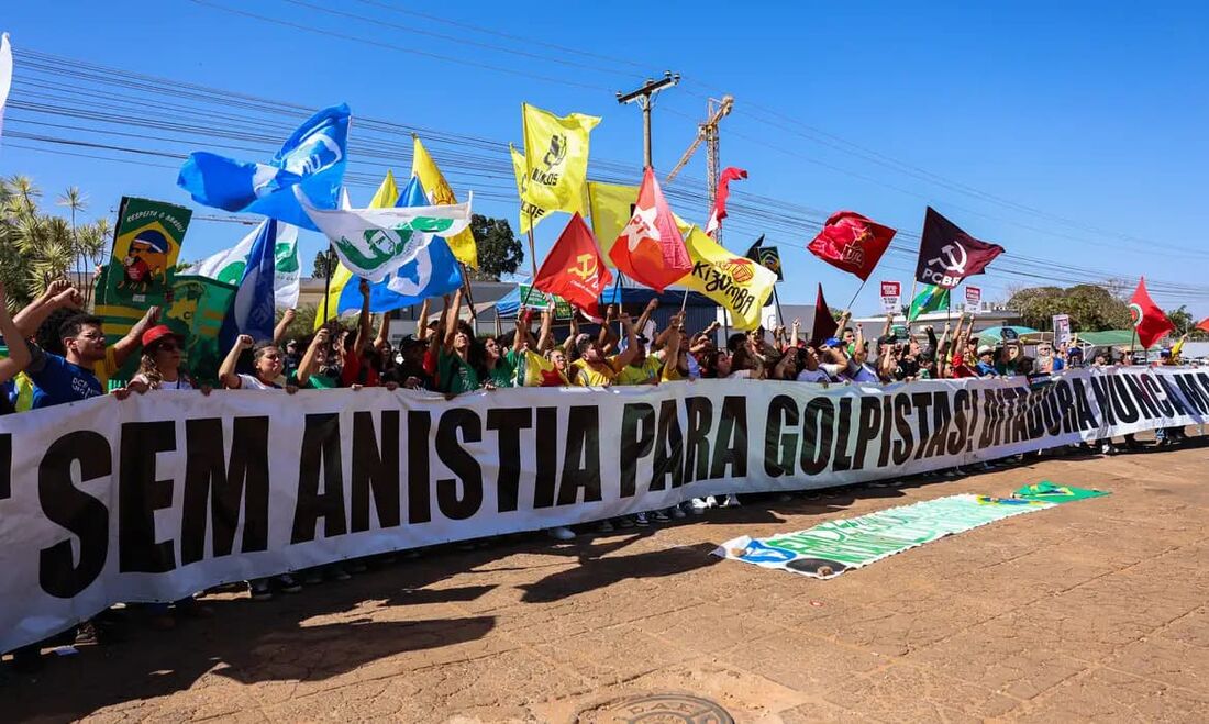 Manifestantes queimam bandeira dos EUA e boneco de Trump em embaixada.