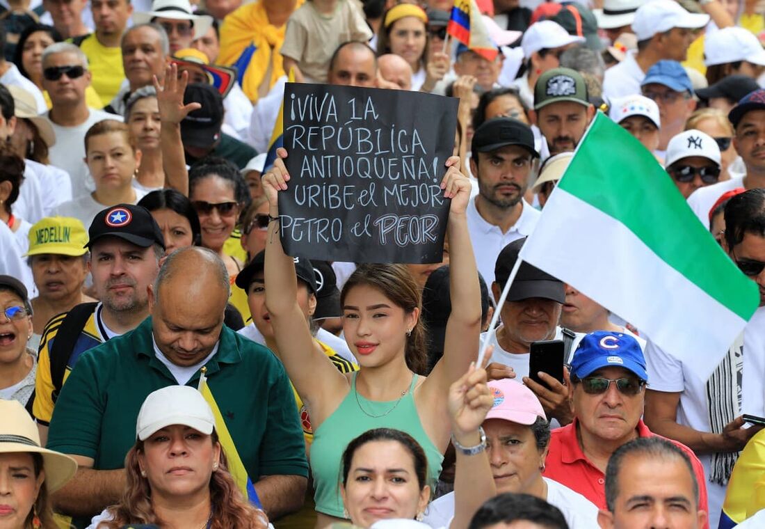 Uma mulher segura uma placa com os dizeres: "Viva a República de Antioquia! Uribe é o melhor. Petro é o pior" durante um protesto em apoio ao ex-presidente colombiano Álvaro Uribe em Medellín, Colômbia, em 7 de agosto de 2025.