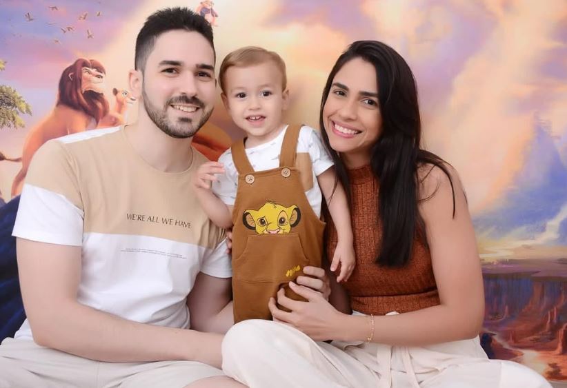 Gabriel, ladeado dos pais, Thiago Cortizo e Bruna Thaísa. Família busca um tratamento inovador com a medicação Elevidys.