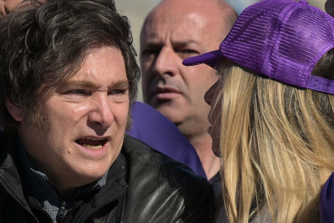 O presidente argentino Javier Milei (E) conversa com sua irmã, a secretária-geral da Presidência, Karina Milei, durante uma carreata em Lomas de Zamora.