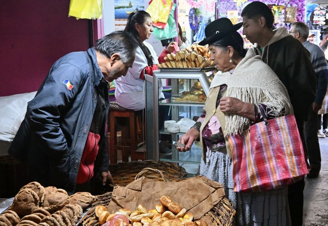 Uma mulher aimará compra pão em um mercado em La Paz, Bolívia, em 31 de julho de 2025. 