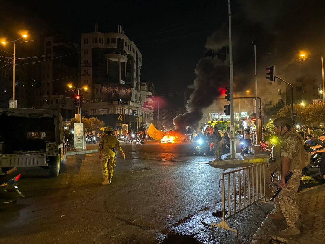 Soldados libaneses observam enquanto apoiadores do grupo militante Hezbollah bloqueiam as ruas com pneus em chamas 