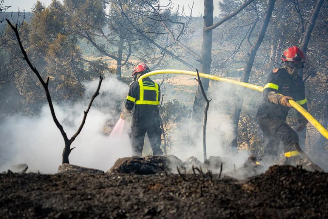 Bombeiros trabalhando para extinguir um incêndio florestal no departamento de Aude, perto de Jonquières, no sul da França.
