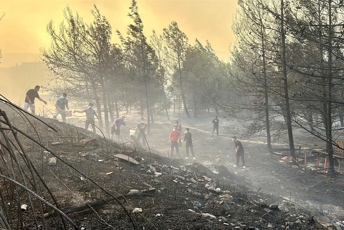 Pessoas trabalhando para extinguir um incêndio florestal em Canakkale, noroeste da Turquia, na região de Mármara.