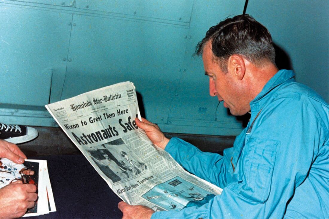 Jim Lovell lendo um recorte de jornal sobre o sucesso de sua missão