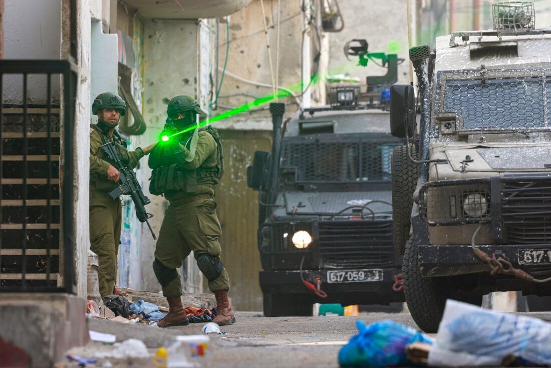 Um soldado israelense aponta sua arma durante um ataque ao campo de refugiados de Balata, a leste da cidade de Nablus, na Cisjordânia ocupada.