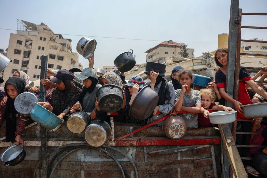 Palestinos disputam por comida em um centro de distribuição de ajuda humanitária na Faixa de Gaza