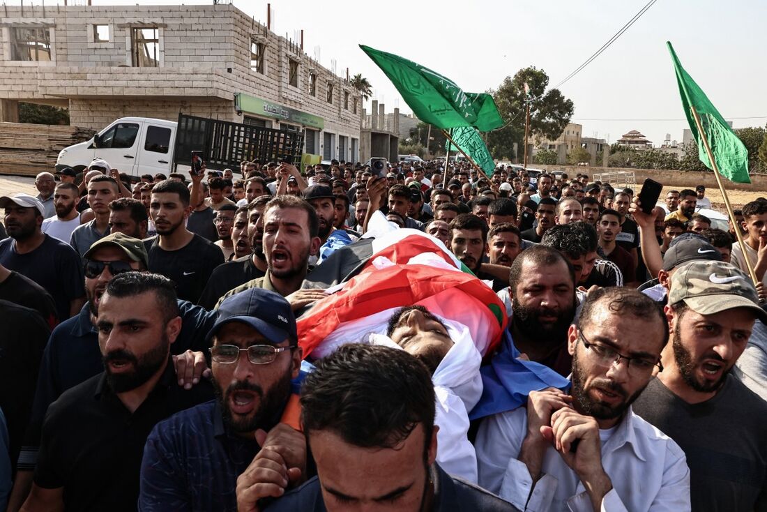 Enlutados carregam o corpo de Thameen Dawabsheh, palestino de 35 anos, supostamente morto por tiros de colonos na vila de Duma, na Cisjordânia