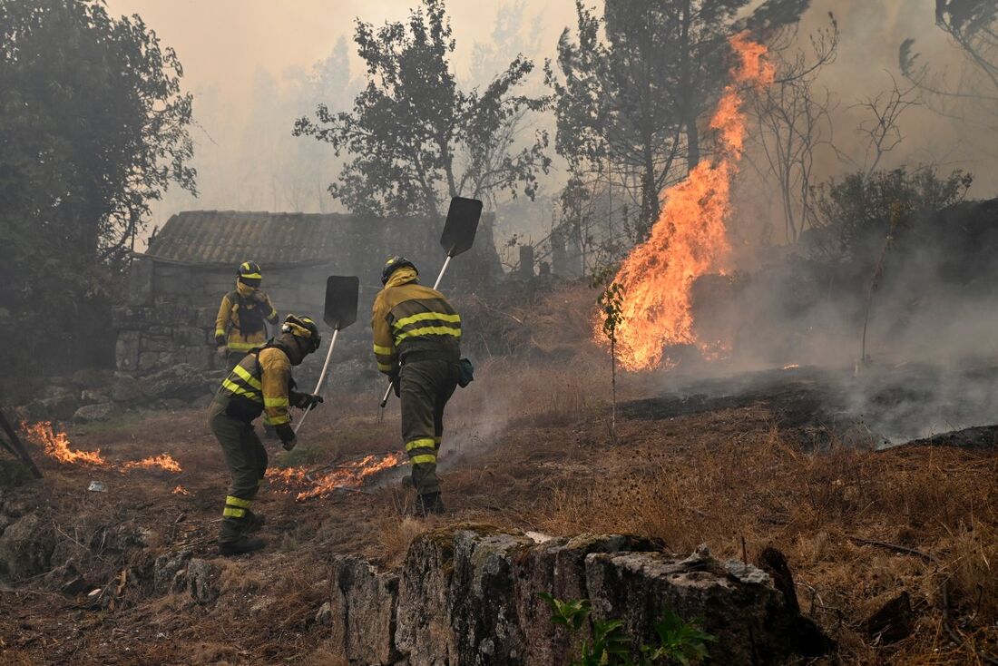 Bombeiros florestais combatem incêndio florestal na aldeia de Vilarino, no município de Carballeda de Avia, noroeste da Espanha