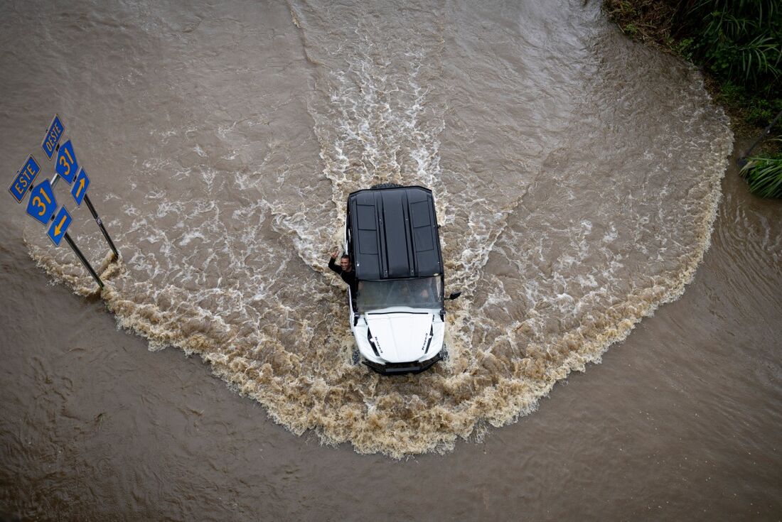 Um carro tenta atravessar uma rodovia inundada em Porto Rico