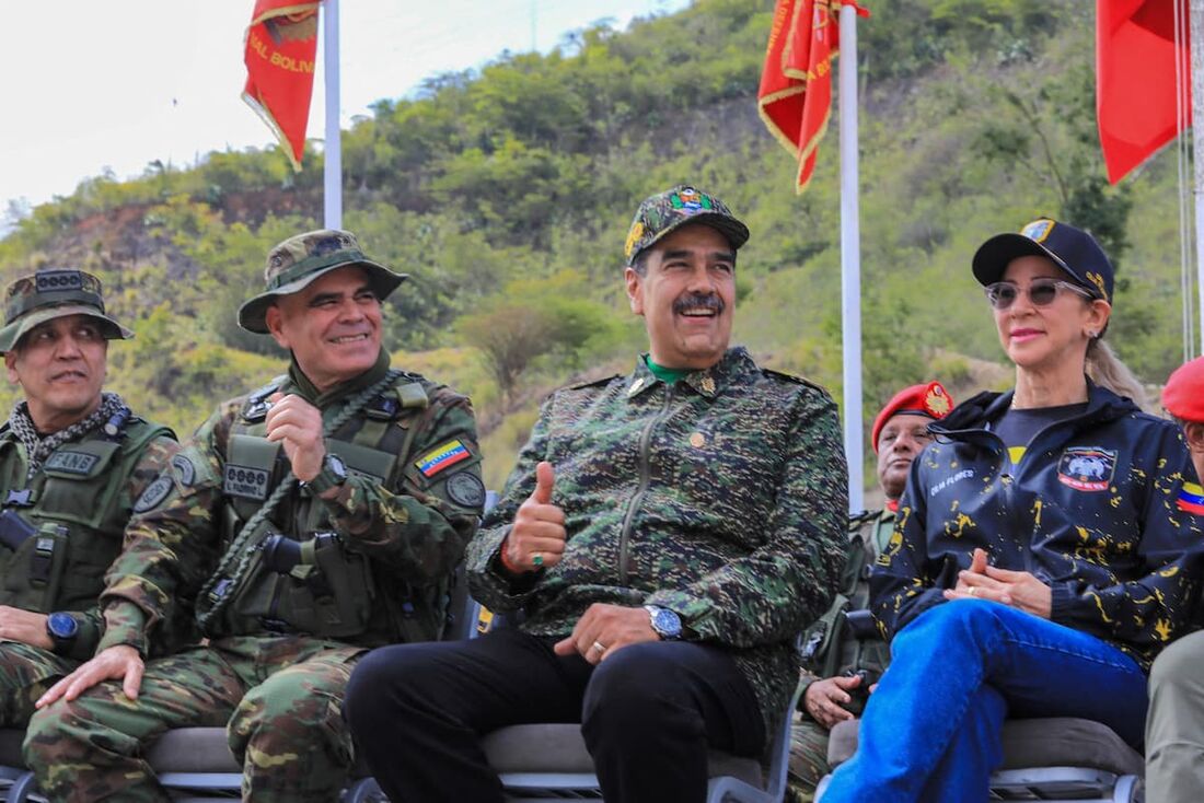 O presidente venezuelano Nicolás Maduro (CR) ao lado do ministro da Defesa, Vladimir Padrino López (CL), e da primeira-dama Cilia Flores (D), enquanto assistem a exercícios militares em um campo de treinamento em Caracas.