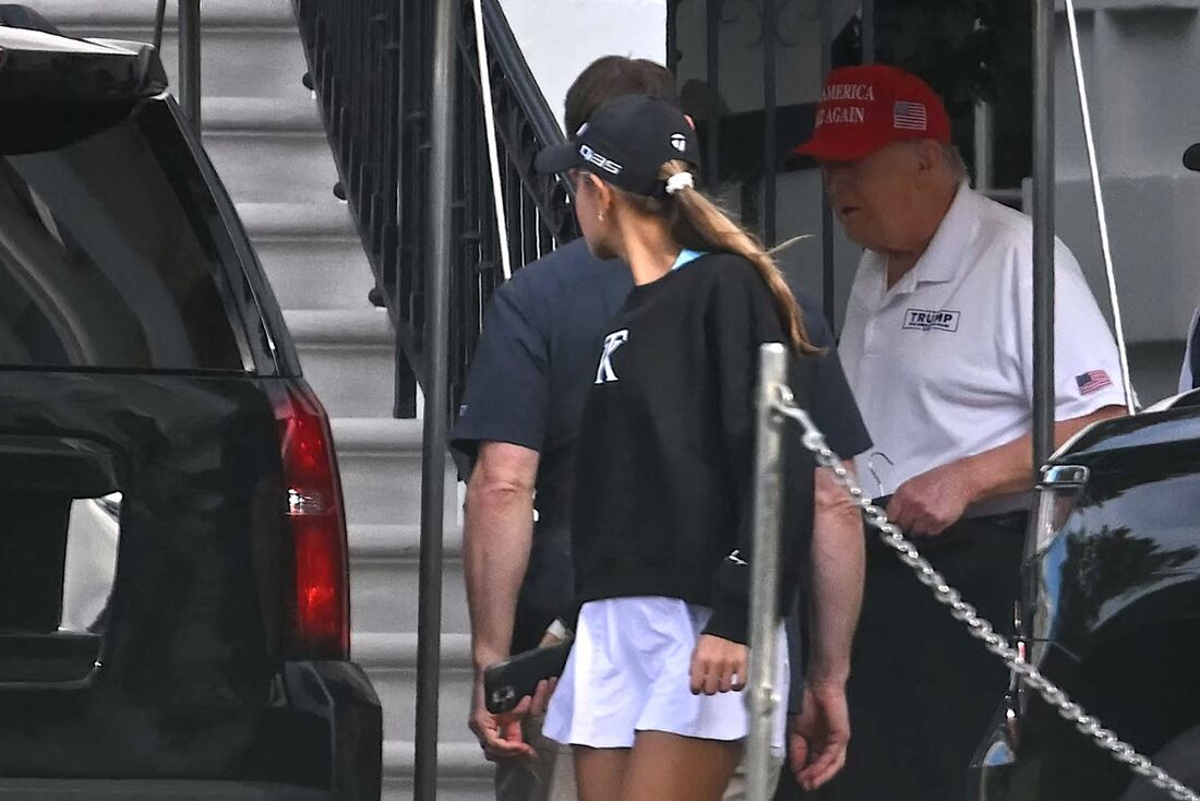 O presidente dos EUA, Donald Trump, e sua neta Kai Trump, a caminho do campo de golfe 