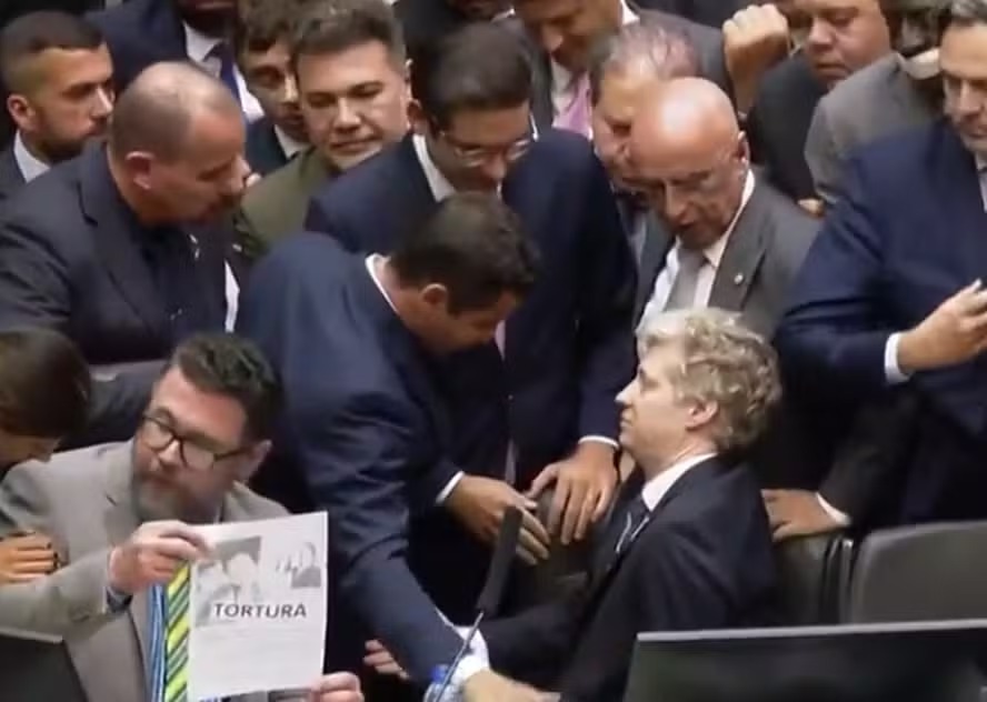 O deputado Marcel Van Hattem resiste em sair da cadeira do presidente da Câmara, Hugo Motta