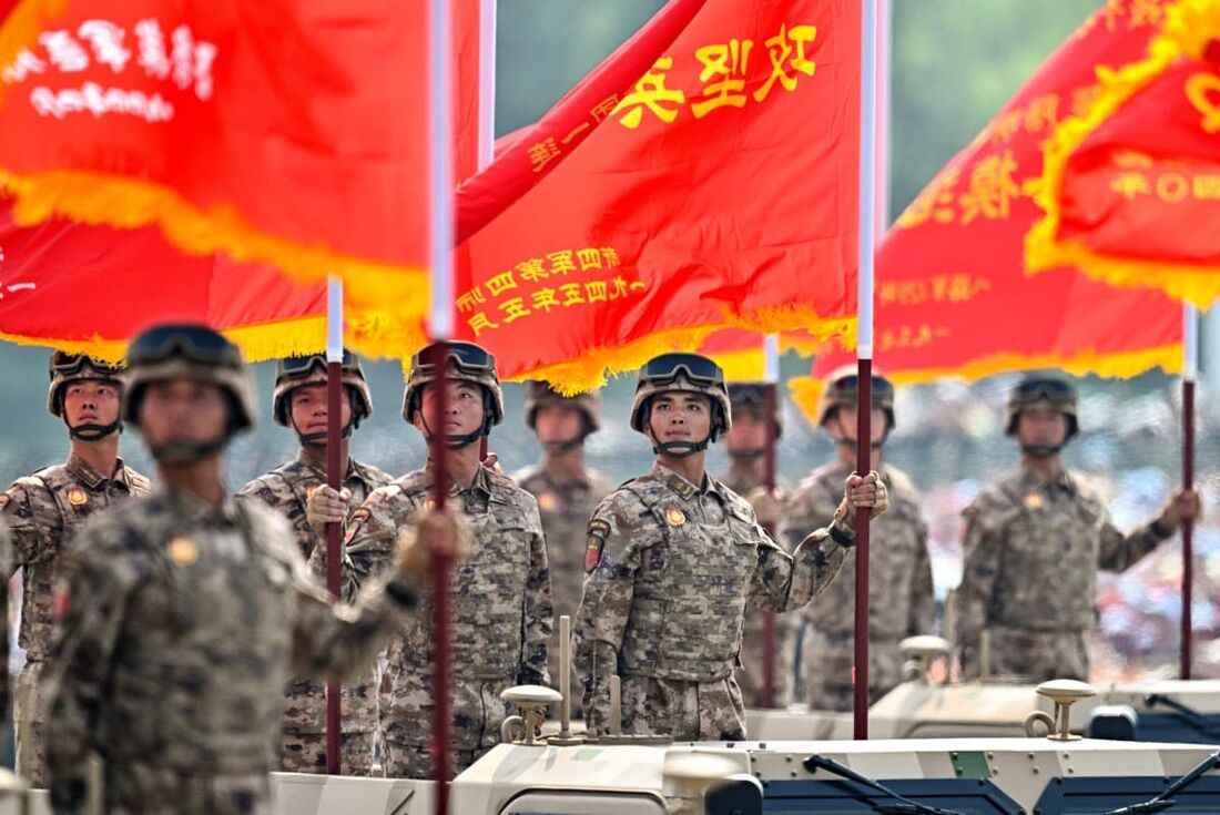 Militares chineses seguram bandeiras durante um desfile militar que marca o 80º aniversário da vitória sobre o Japão e o fim da Segunda Guerra Mundial.