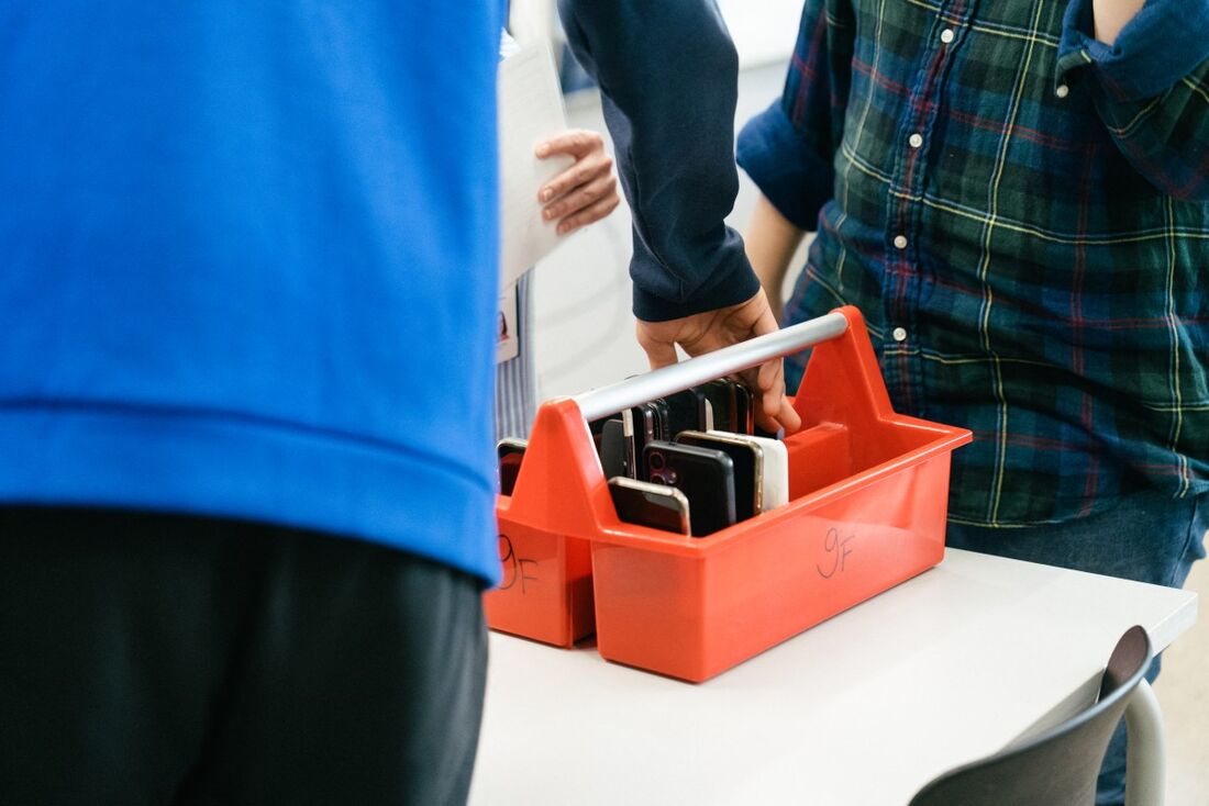 Um aluno da turma 9F mostra como deposita seus smartphones em uma caixa especial no início do dia na escola abrangente de língua sueca Kungsvagens Skola, em 21 de agosto de 2025, em Sipoo, Finlândia.