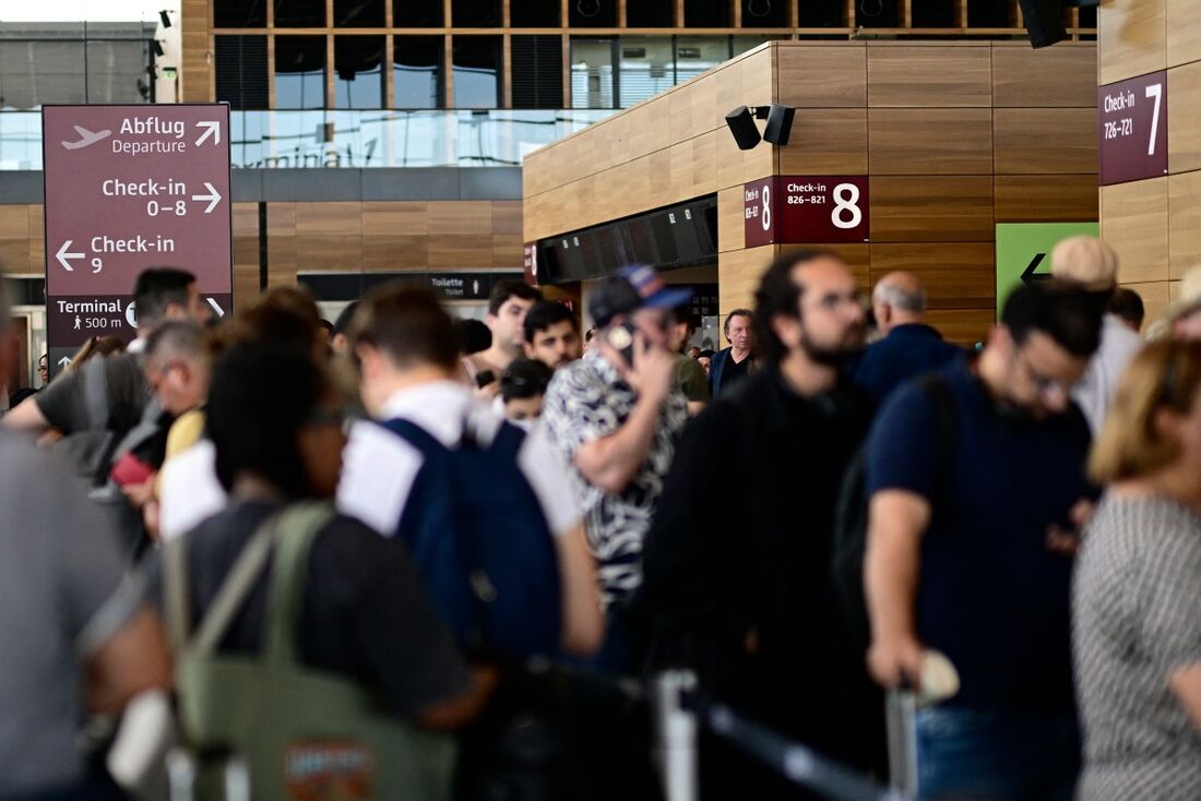 Passageiros fazem fila para check-in no Terminal 1 do Aeroporto Willy-Brandt, em Berlim Brandemburgo, BER, em Schoenefeld, a sudeste de Berlim, em 20 de setembro de 2025, após grandes aeroportos europeus terem sido atingidos por "interrupções cibernéticas