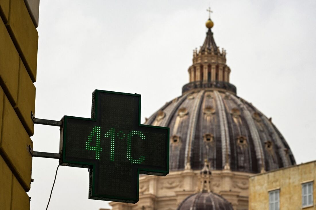Placa de farmácia indicando a temperatura externa atual como 41 graus Celsius, com a cúpula da Basílica de São Pedro ao fundo, em Roma