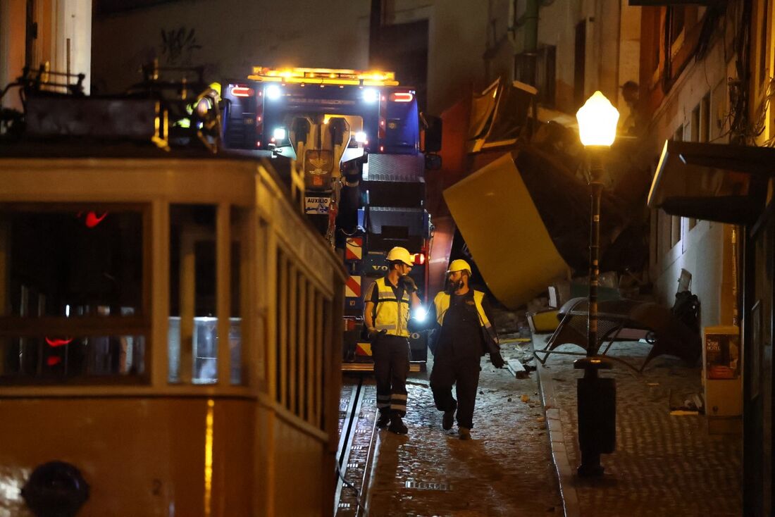 Trabalhadores removem os destroços do acidente do funicular da Glória, em Lisboa.