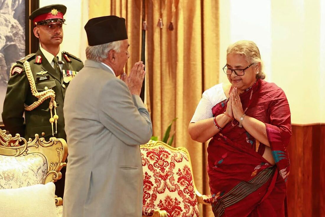 O presidente do Nepal, Ram Chandra Paudel (E), gesticula após prestar juramento à recém-nomeada primeira-ministra do país, Sushila Karki, durante sua cerimônia de posse na Casa Presidencial em Katmandu