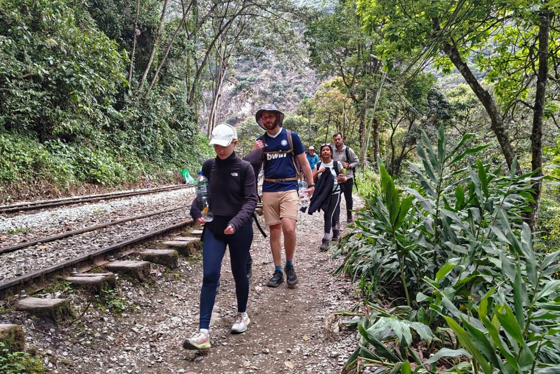 Um grupo de turistas sai a pé devido a um protesto de moradores em Machu Picchu Pueblo, Peru