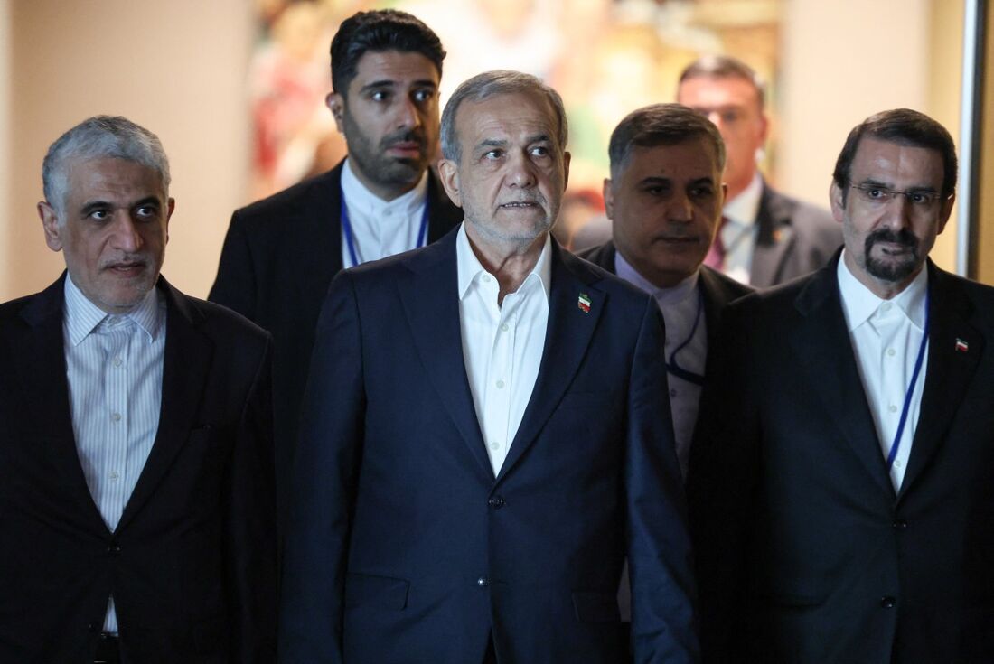 O presidente do Irã, Masoud Pezeshkian (C), caminha a caminho de uma reunião bilateral com o presidente francês, Emmanuel Macron