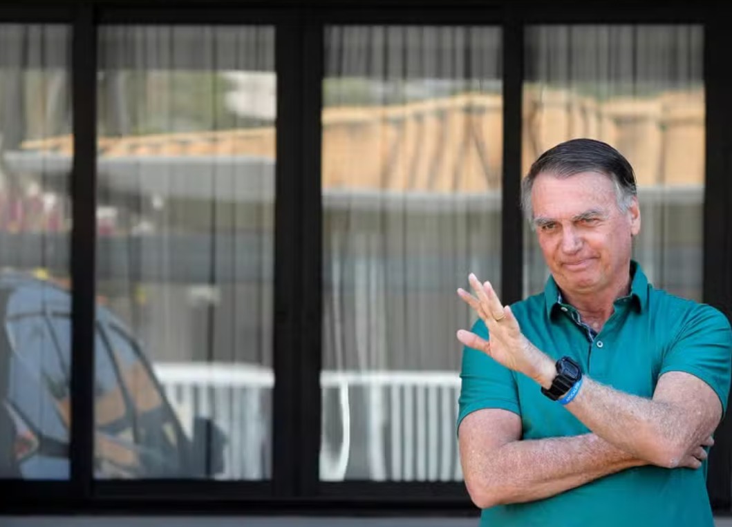 O ex-presidente brasileiro Jair Bolsonaro acena em sua residência em Brasília