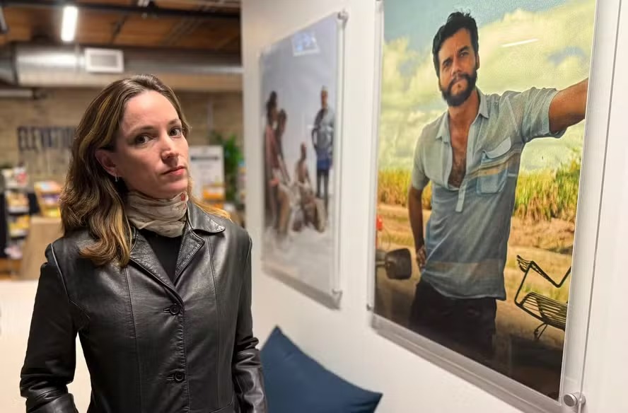 Emilie Lesclaux, produtora de 'O agente secreto', ao lado de cartaz com o ator Wagner Moura 