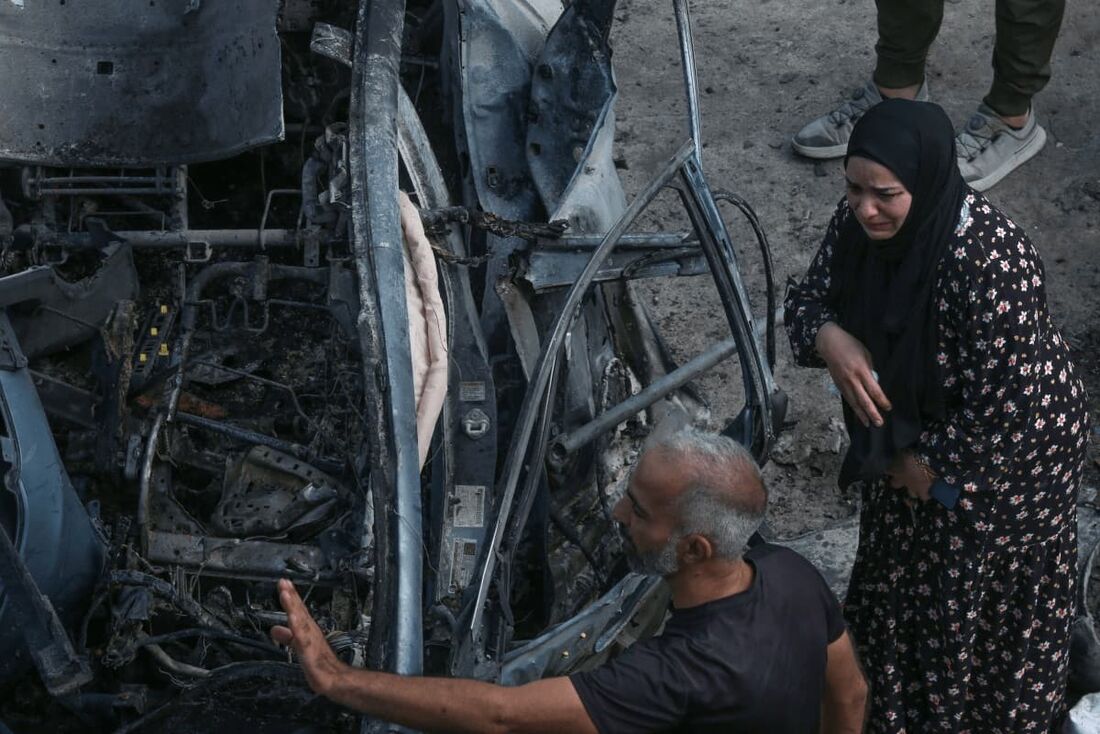 Uma mulher libanesa chora ao se aproximar de um carro destruído alvo de um ataque de drone israelense na vila de Zebdine, no sul do Líbano