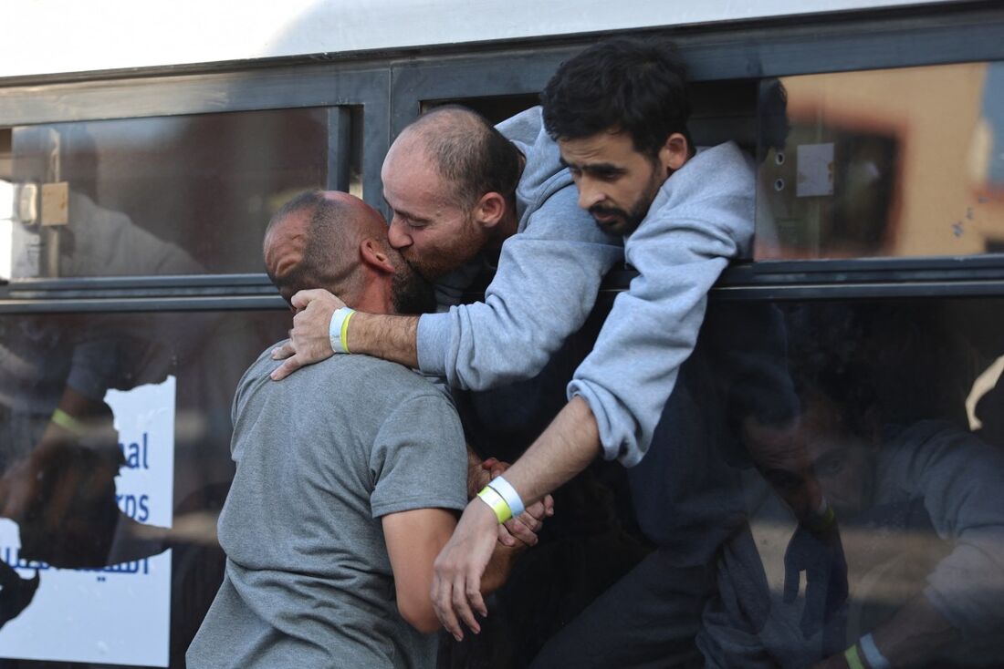 Um palestino libertado de prisões israelenses sob um cessar-fogo em Gaza e um acordo de troca de reféns com facções palestinas cumprimenta um parente ao chegar de ônibus