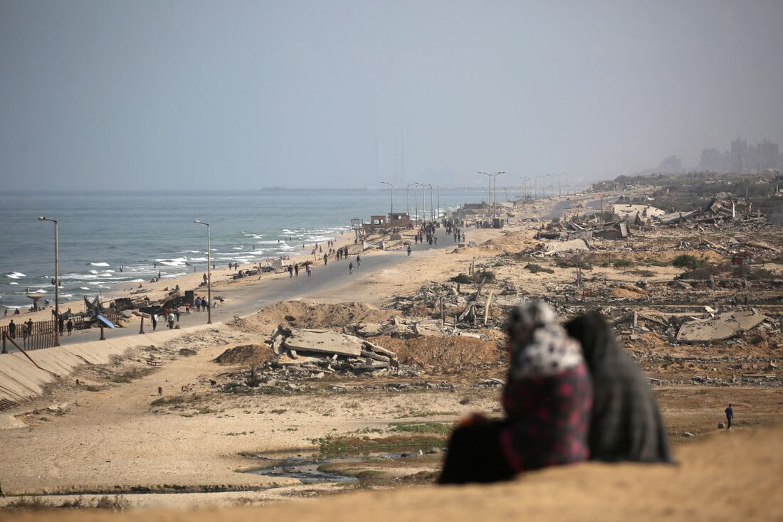 Palestinos caminham por uma trilha costeira a noroeste do campo de refugiados de Nuseirat enquanto são deslocados para o sul após o anúncio israelense de fechar a estrada Al-Rashid em direção ao norte da Faixa de Gaza sitiada