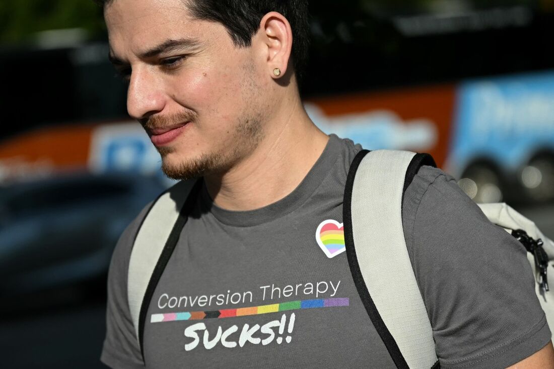 Um homem veste uma camisa com os dizeres "terapia de conversão é uma droga" em frente à Suprema Corte dos EUA