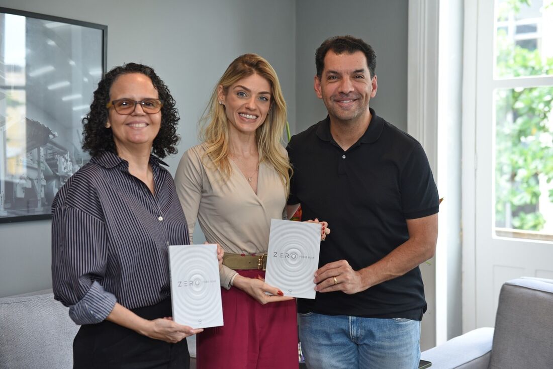 Leusa Santos, editora-chefe da Folha (esq) e Mariana Costa, vice-presidente (cen) recebem livro "Zero", das mãos de Fábio Silva, CEO da Rede Muda Mundo